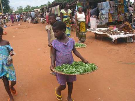 Tovor Djatougbe , 13 ans, vend des légumes au marché de Togoville, 40 kilomètres de Lomé (ph. Xinhua)