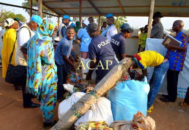 Scène de fouille systématique des bagages avant leur embarquement, du camp de Pladama Ouaka vers l'aérodrome de Bambari