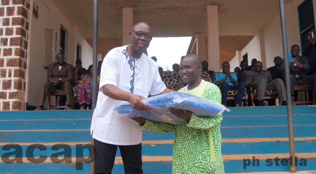 Félix Moloua remettant un kit à un agriculteur devant les locaux de l'ISDR de Mbaïki