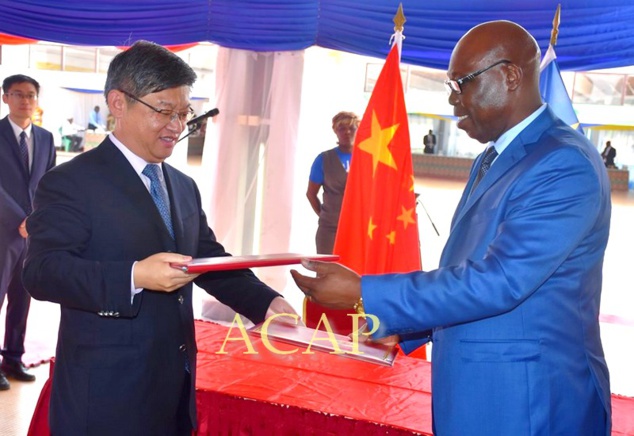 Echange des documents entre le ministre Moloua (en bleu) et l'ambassadeur Chen Dong