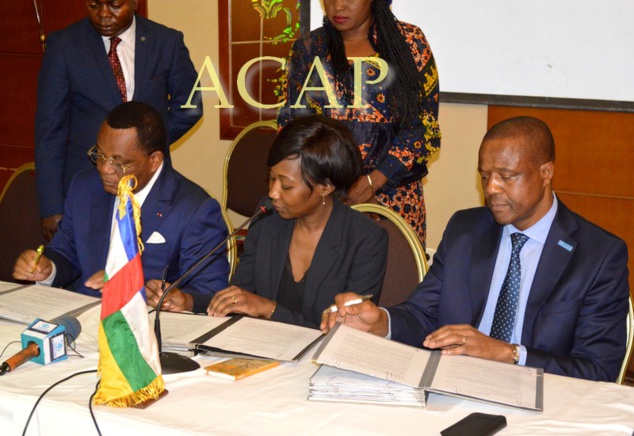 Scène de la signature de l'accord tripartite