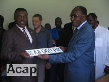 Le ministre d'Etat en charge des transport, Charles Massi remet au Premier ministre Elie Doté (à gauche) sa nouvelle plaque d'immatriculation Cémac, le 25 août 2006 (ph. debato/Acap)