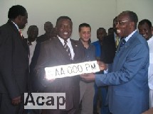 le Premier ministre Elie Doté content de recevoir sa nouvelle plaque d'immatriculation Cémac en août 2006 (ph. debato/Acap)