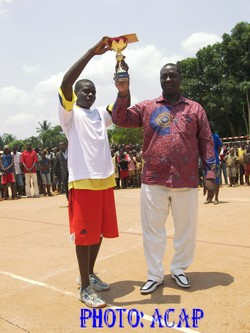 M. Désiré Zanga Kolingba remettant son trophée à l'un des vainqueurs de la coupe Eco Junior