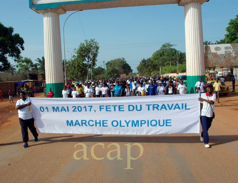 Des travailleurs participent à une marche olympique en prélude à la fête du travail