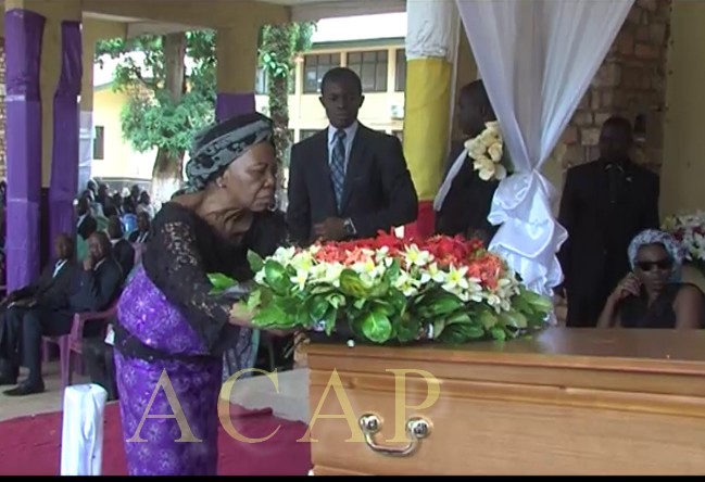 La veuve Pouzère déposant une gerbe de fleurs sur le cercueil de son défunt mari