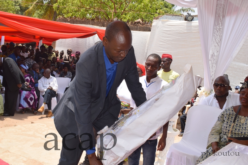 Le directeur de l'ACAP, Simon-Pierre Ndouba, déposant une gerbe de fleurs sur le cercueil de son défunt prédécesseur