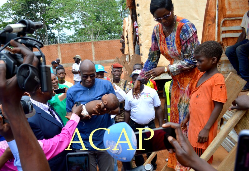 Mme Virginie Mbaïkoua remettant un bébé né parmi les réfugiés de Bétou à M. Raouf Mazou à leur arrivée à Moungouba