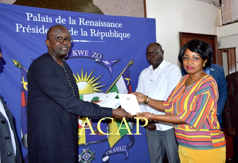Mme Léonie Banga-Boti recevant des mains de Freddy Nkurikiyéquelques copies de l'Accord de paix et de réconciliation