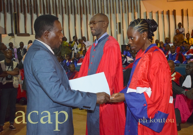 Deux jeunes médecins ressortissants de la FACSS recevant leur diplôme des mains du ministre Jean-Jacques Sanzé