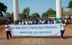 Des travailleurs participent à une marche olympique en prélude à la fête du travail